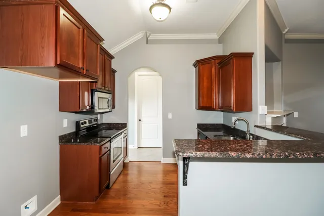 a kitchen with stainless steel appliances granite countertop a sink stove and cabinets