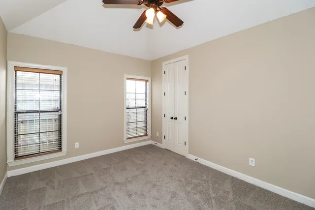 an empty room with windows and closet