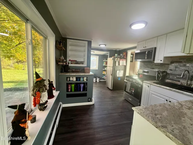 a kitchen with stainless steel appliances granite countertop sink stove top oven and cabinets