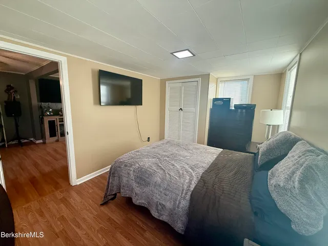 a bedroom with a bed and wooden floor