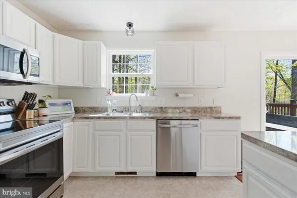 a kitchen with granite countertop white cabinets and a stove