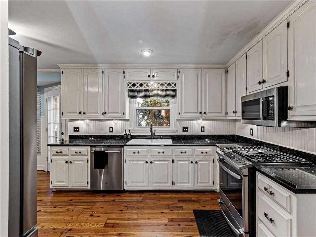 215 Pineywood Road Griffin, GA 30224 - Photo 20 of 49 a kitchen with stainless steel appliances granite countertop a stove sink and cabinets