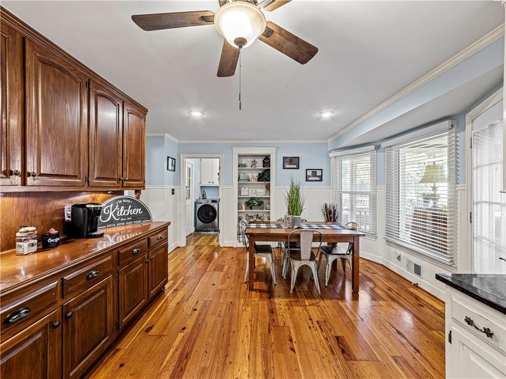 215 Pineywood Road Griffin, GA 30224 - Photo 24 of 49 a kitchen with stainless steel appliances granite countertop a stove top oven a dining table and chairs with wooden floor