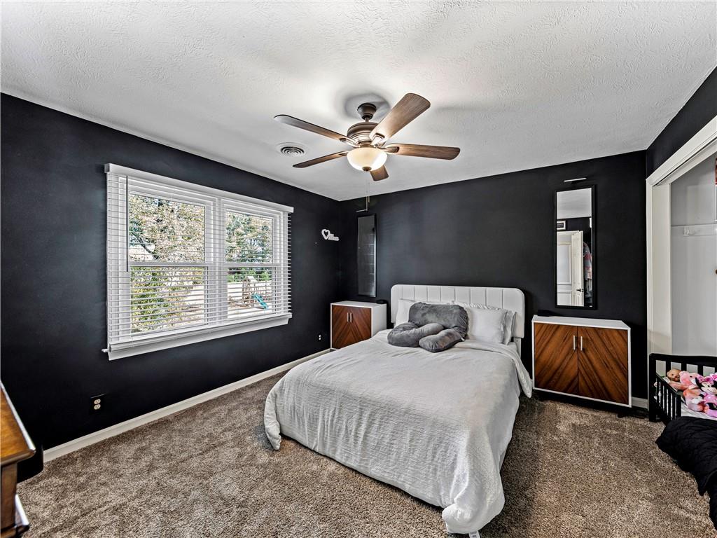 215 Pineywood Road Griffin, GA 30224 - Photo 29 of 49 a bedroom with a large bed and a chandelier