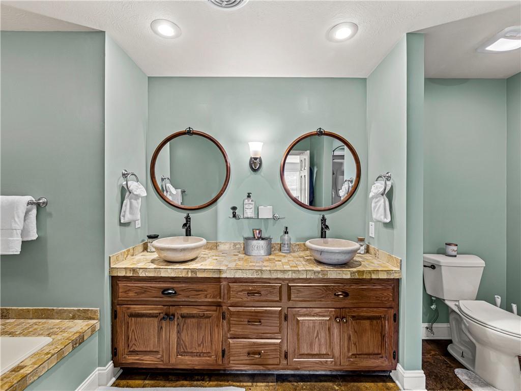215 Pineywood Road Griffin, GA 30224 - Photo 36 of 49 a bathroom with a granite countertop toilet a mirror and a sink