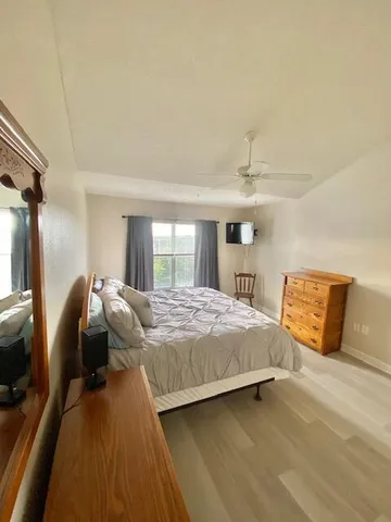 a bedroom with a bed and wooden floor