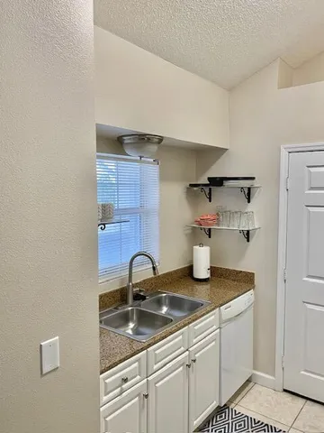 a kitchen with a sink a stove and cabinets