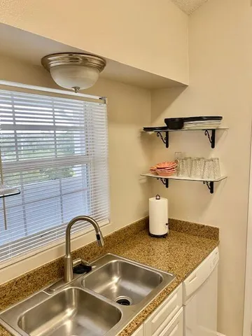 a kitchen with a sink and a wooden floor