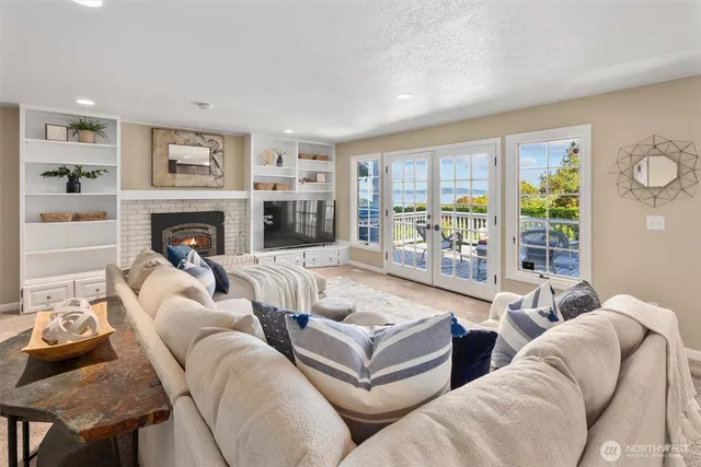 a living room with furniture fireplace and a large window