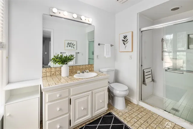 a bathroom with a granite countertop sink toilet and shower