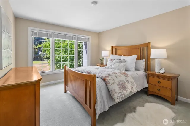 a bedroom with a bed and large windows