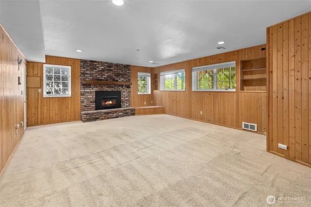 a view of an empty room with a fireplace and a window