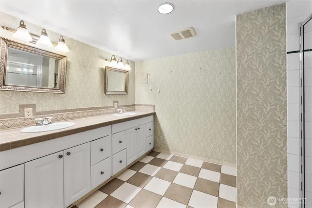 a spacious bathroom with a double vanity sink mirror and double
