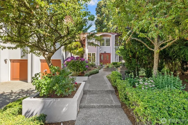 a view of a house with a yard and potted plants