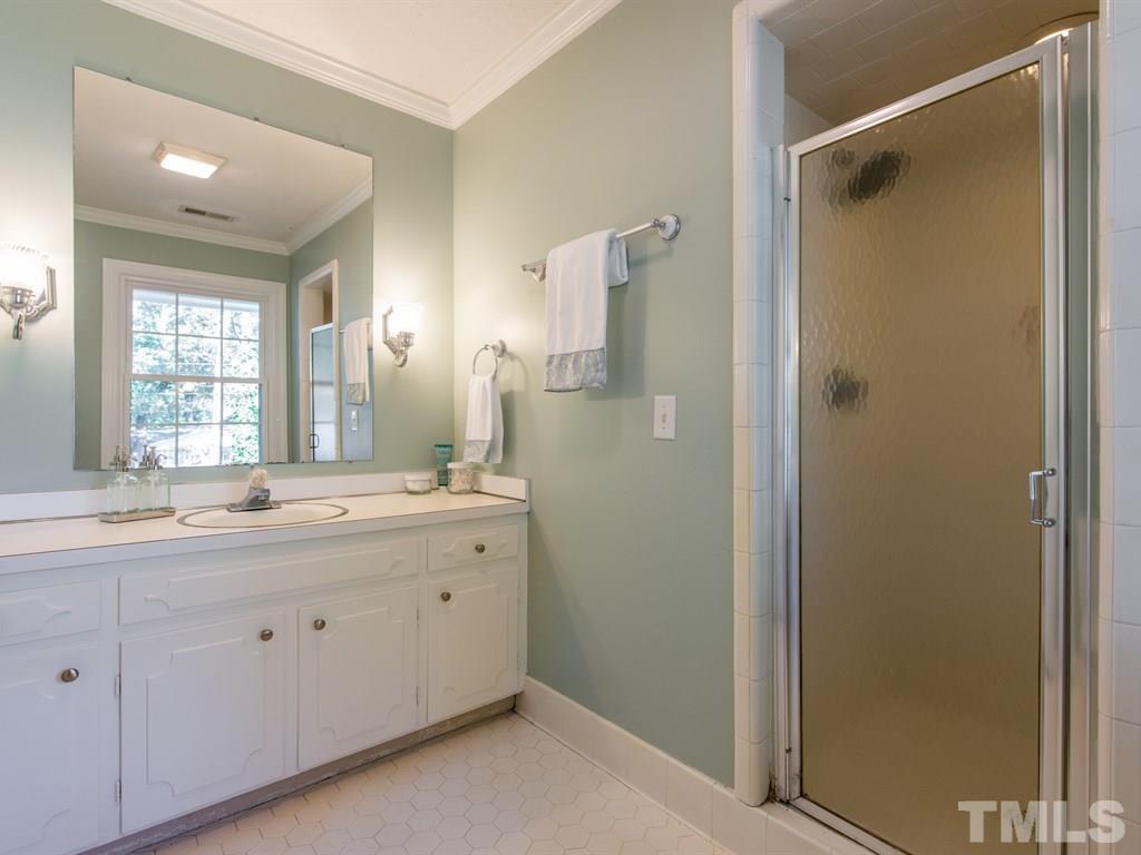 6925 Electra Drive Raleigh, NC 27607 - Photo 16 of 25 a spacious bathroom with a granite countertop sink mirror and a shower