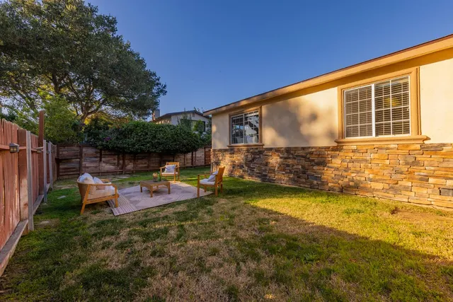 a view of a house with backyard and sitting area