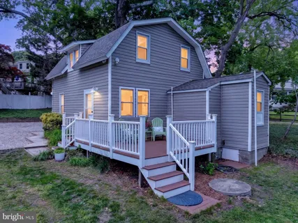 a view of a small house with a yard and furniture