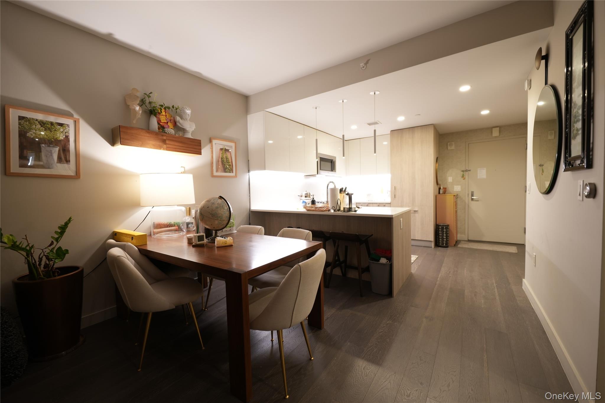 131-03 40 Road, Unit 18V Queens, NY 11354 - Photo 2 of 9 a dining room with kitchen island a table and chairs