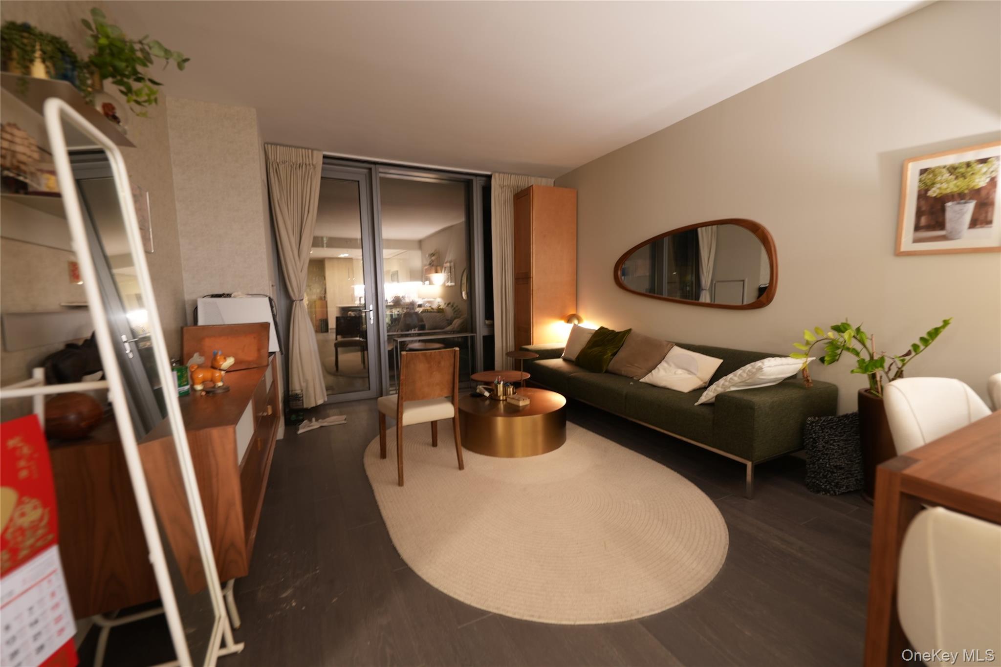 131-03 40 Road, Unit 18V Queens, NY 11354 - Photo 7 of 9 a living room with furniture and a floor to ceiling window