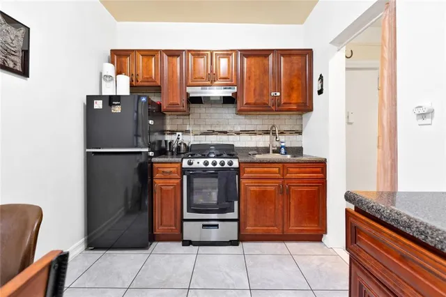 a kitchen with stainless steel appliances granite countertop a refrigerator stove and sink
