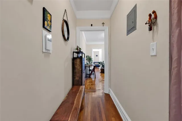 a view of a hallway with wooden floor and closet