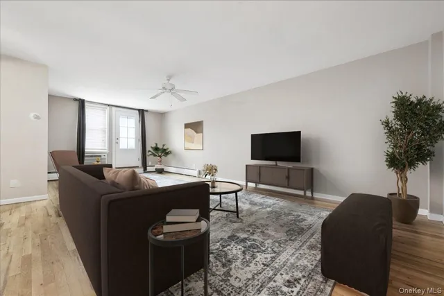 a living room with furniture a flat screen tv and a large window