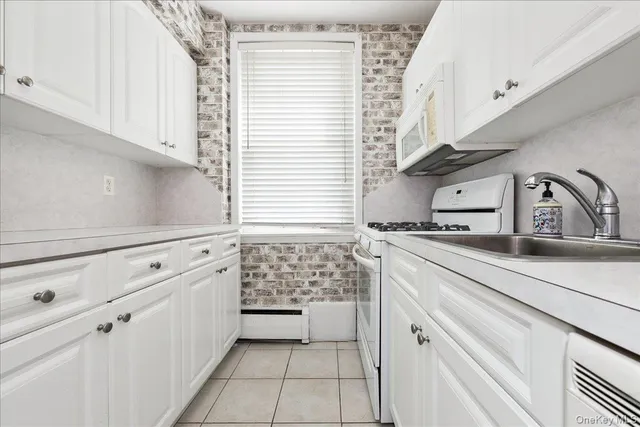 a kitchen with white cabinets and white appliances