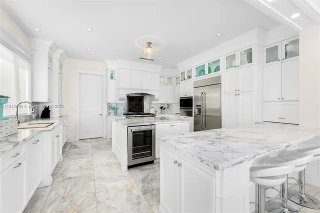 a kitchen with granite countertop a sink stove and refrigerator