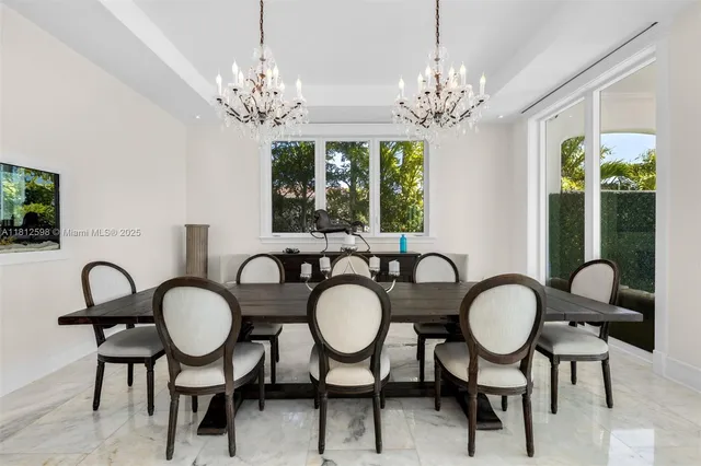 a view of a dining room with furniture a chandelier and large window