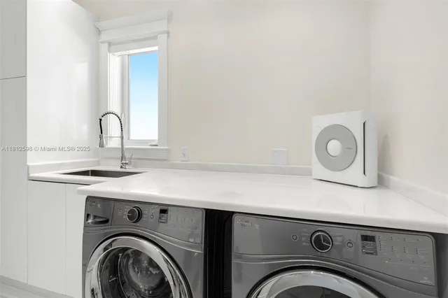 a utility room with sink dryer and washer