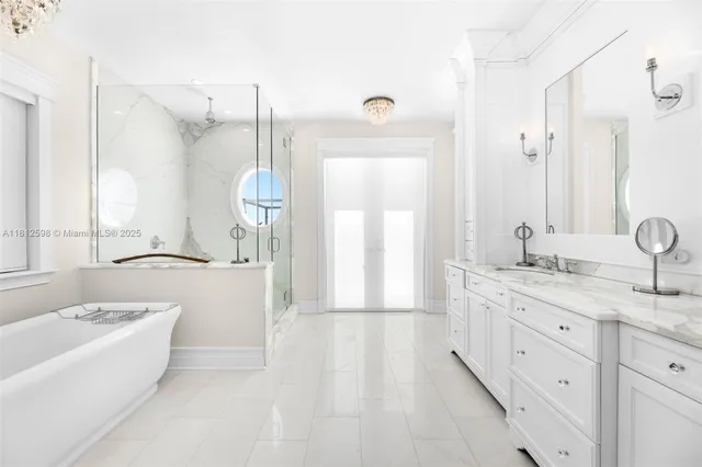 a bedroom with a large bed and a chandelier