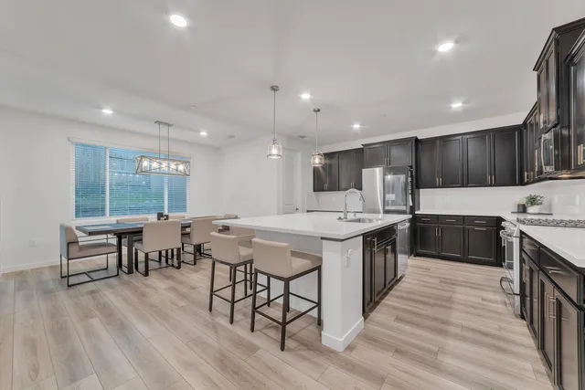 a kitchen with a table chairs sink and cabinets