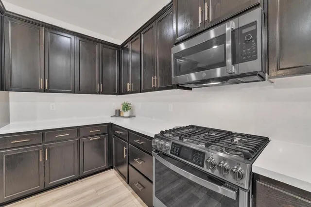 a kitchen with stainless steel appliances granite countertop a stove and a microwave