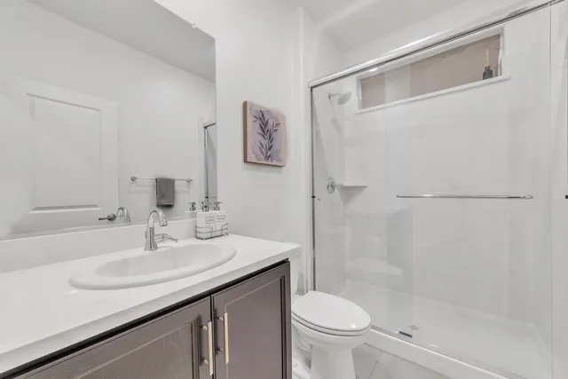 a bathroom with a granite countertop sink toilet and shower