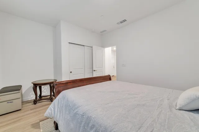 a spacious bedroom with a bed and a chair