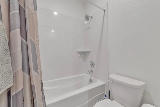 a bathroom with a bathtub a toilet and a shower