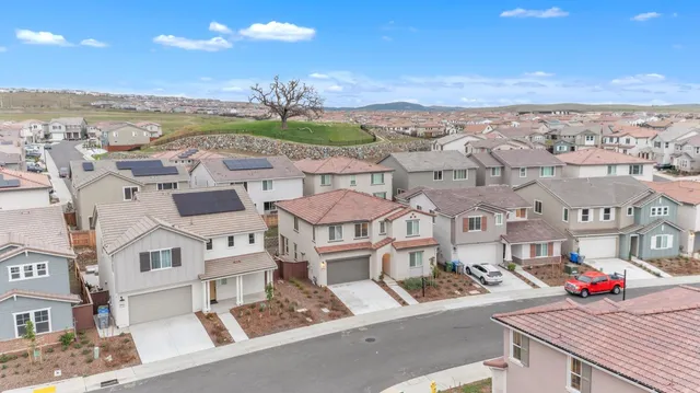 an aerial view of residential houses with outdoor space and ocean view