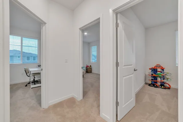 a bedroom with a bed a table and windows