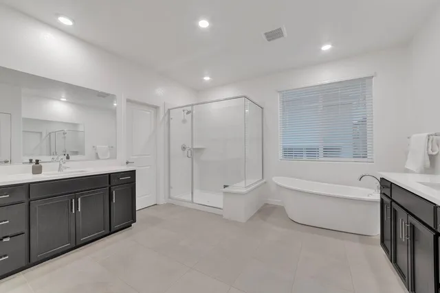 a bathroom with a tub sink and mirror