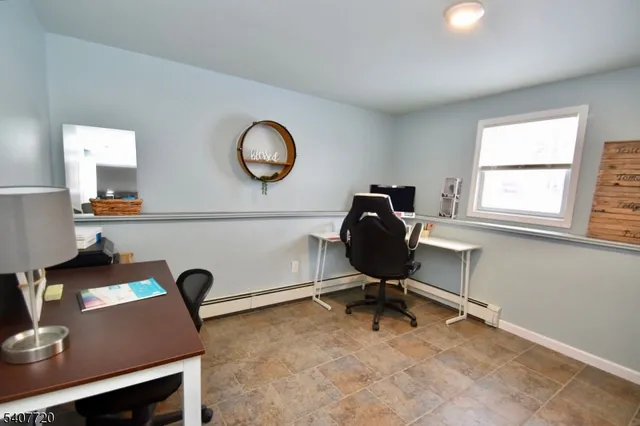 a view of a workspace with furniture and a window