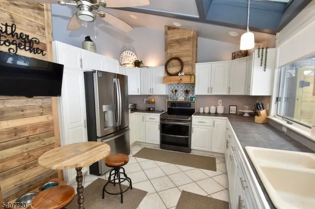 a kitchen with granite countertop a stove a refrigerator and a microwave