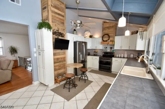 a living room with furniture a flat screen tv and kitchen view