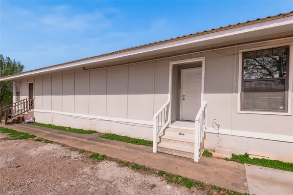 a view of a house with backyard and a tree
