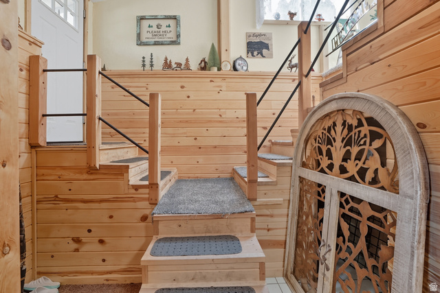 667 North Rapid Creek Road Inkom, ID 83245 - Photo 3 of 29 Natural wood plank walls and staircase featuring carpeted treads and black metal railings