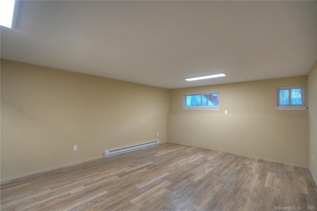 528 Shennecossett Road, Unit 14 Groton, CT 06340 - Photo 17 of 18 an empty room with wooden floor and windows