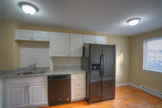 a kitchen with granite countertop a refrigerator and a sink