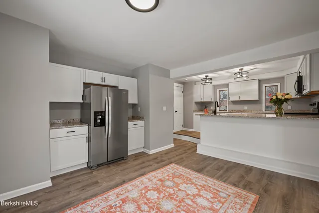 a kitchen with stainless steel appliances granite countertop a refrigerator and a stove top oven