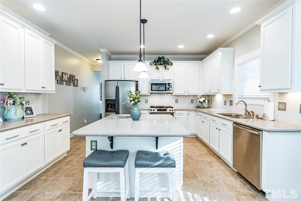 8240 Clarks Branch Drive Raleigh, NC 27613 - Photo 11 of 30 a kitchen with kitchen island granite countertop a sink a center island and cabinets