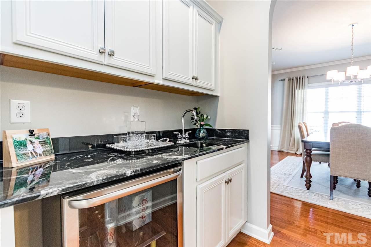 8240 Clarks Branch Drive Raleigh, NC 27613 - Photo 14 of 30 a kitchen with granite countertop a sink a stove and wooden floors