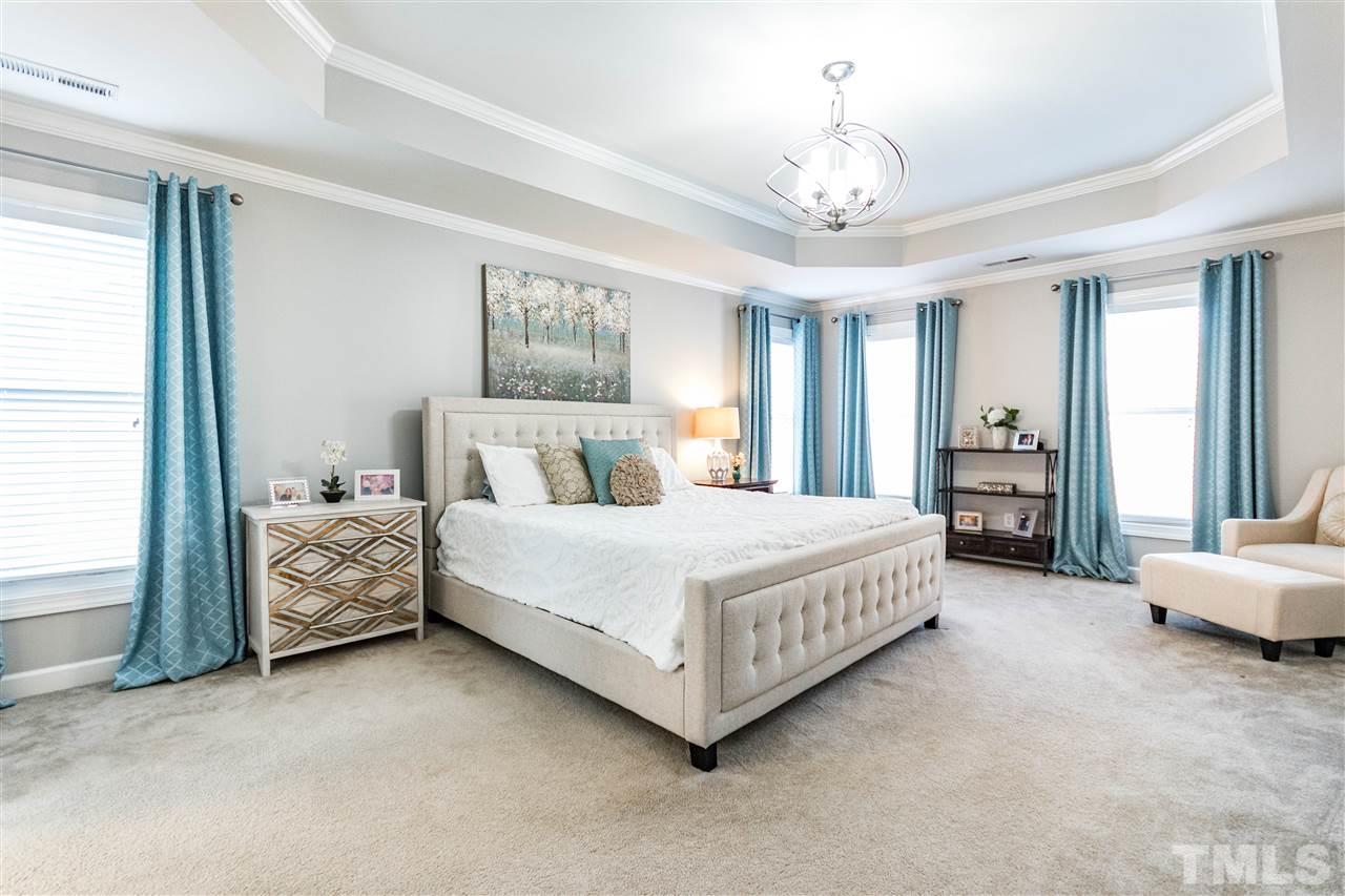 8240 Clarks Branch Drive Raleigh, NC 27613 - Photo 17 of 30 a spacious bedroom with a bed and a chandelier